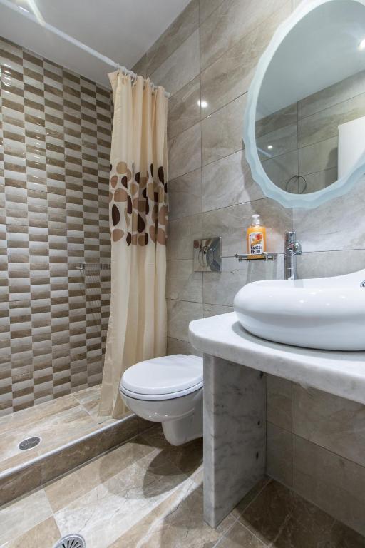 a bathroom with a sink and a toilet and a mirror at Relax Studios in Naxos Chora