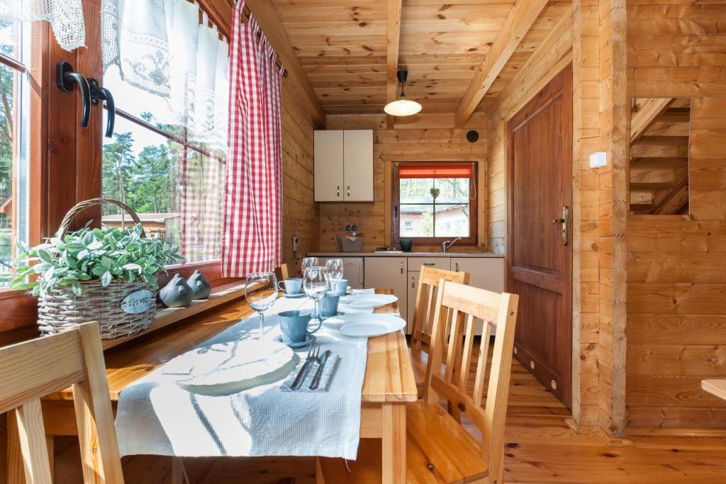 a dining room with a table in a wooden house at Adria Domki in Pobierowo