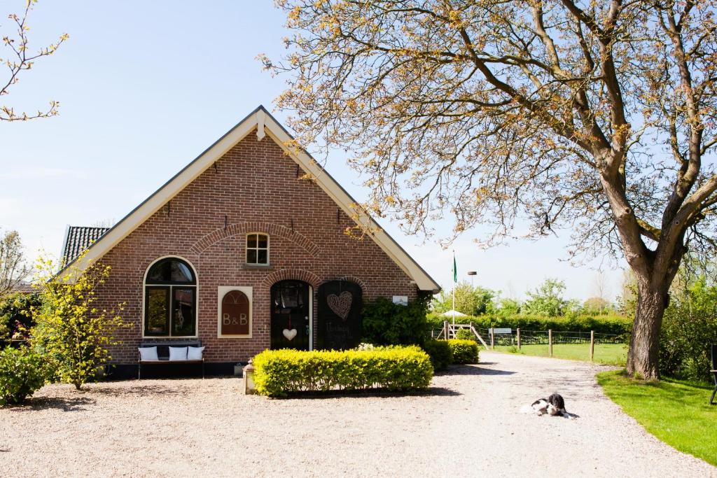 a dog laying in front of a brick church at Bed and Breakfast Klein Groenbergen in Leersum