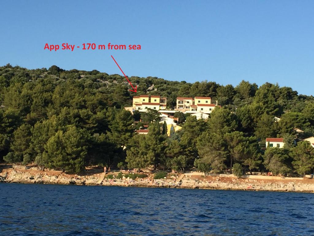 a kite flying over the water in front of a house at Apartment Sky View in Cres