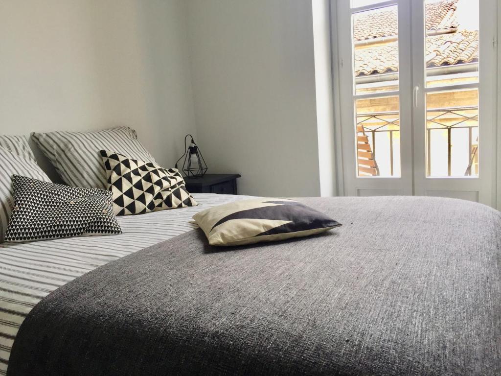 une chambre avec un lit avec des oreillers et une fenêtre dans l'établissement Le charmant quai bourgeois, à Bordeaux