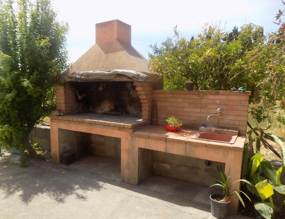 un horno al aire libre con fregadero en un jardín en Appartamenti Alessio en Girasole