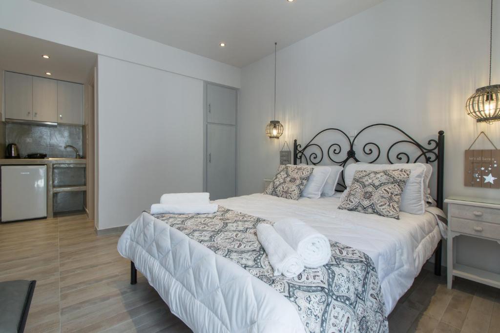 a bedroom with a large bed with white sheets and pillows at Relax Studios in Naxos Chora