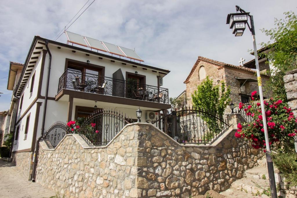 a house with balconies and a stone wall at Apartments St Dimitrij in Ohrid