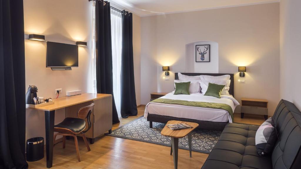 a hotel room with a bed and a desk and a couch at Antler Boutique in Braşov