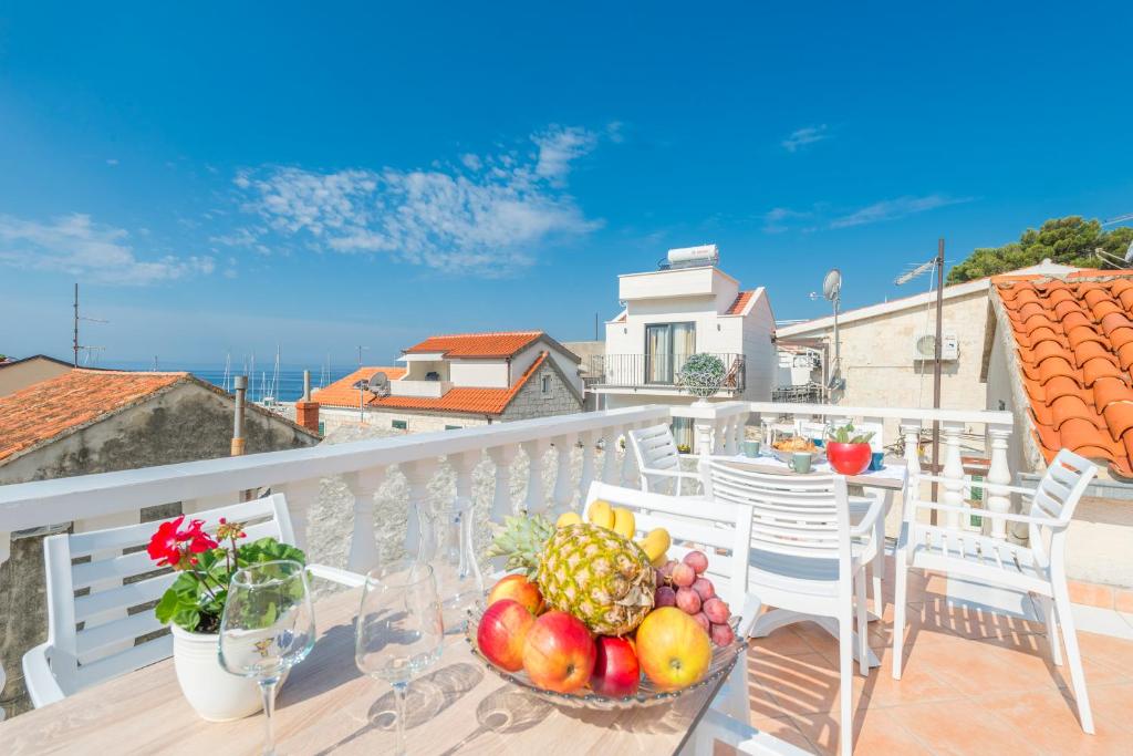 a table with a bowl of fruit on a balcony at Apartments Roma in Baška Voda