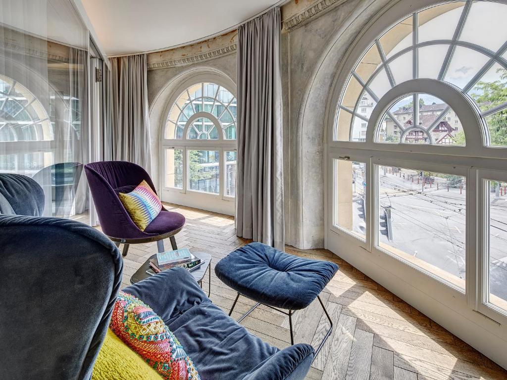 uma sala de estar com cadeiras e uma grande janela em Hotel Anker Luzern em Lucerna