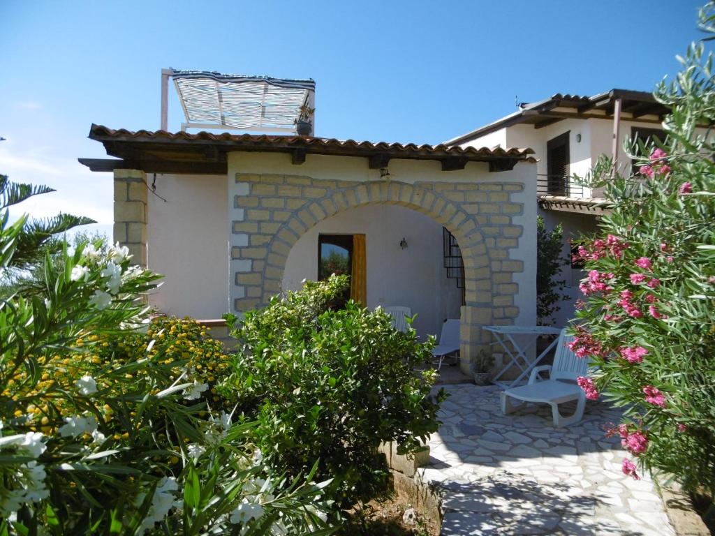 ein kleines Haus mit einem Torbogen in einem Garten in der Unterkunft Casa Lucrezia in Balestrate