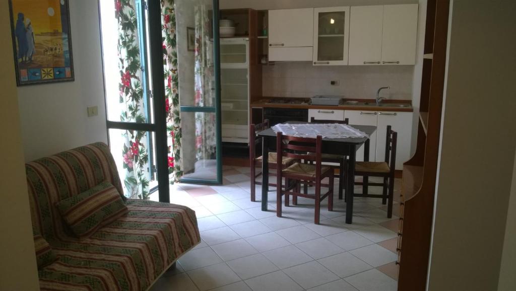 sala de estar con mesa y sillas y cocina en Gemma del Sud, en Scilla