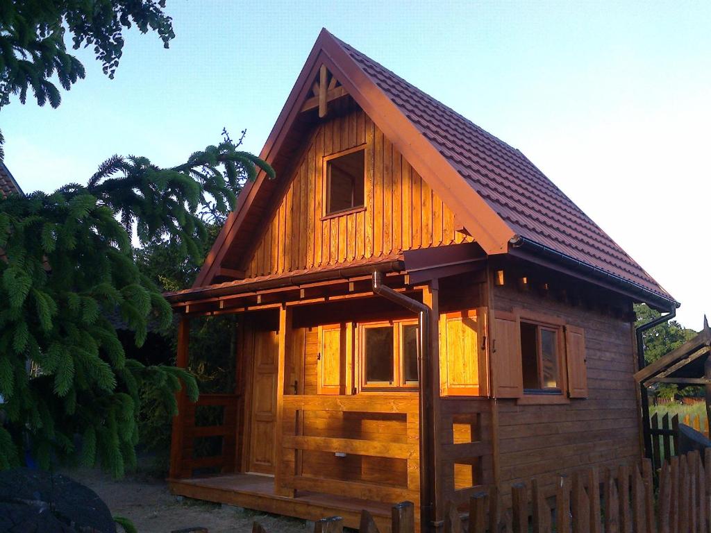 uma pequena cabana de madeira com um telhado de gambrel em Nowe Domki Pod Lipami em Junoszyno