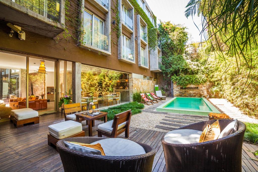 un patio al aire libre con sillas y una piscina en Mine Hotel en Buenos Aires