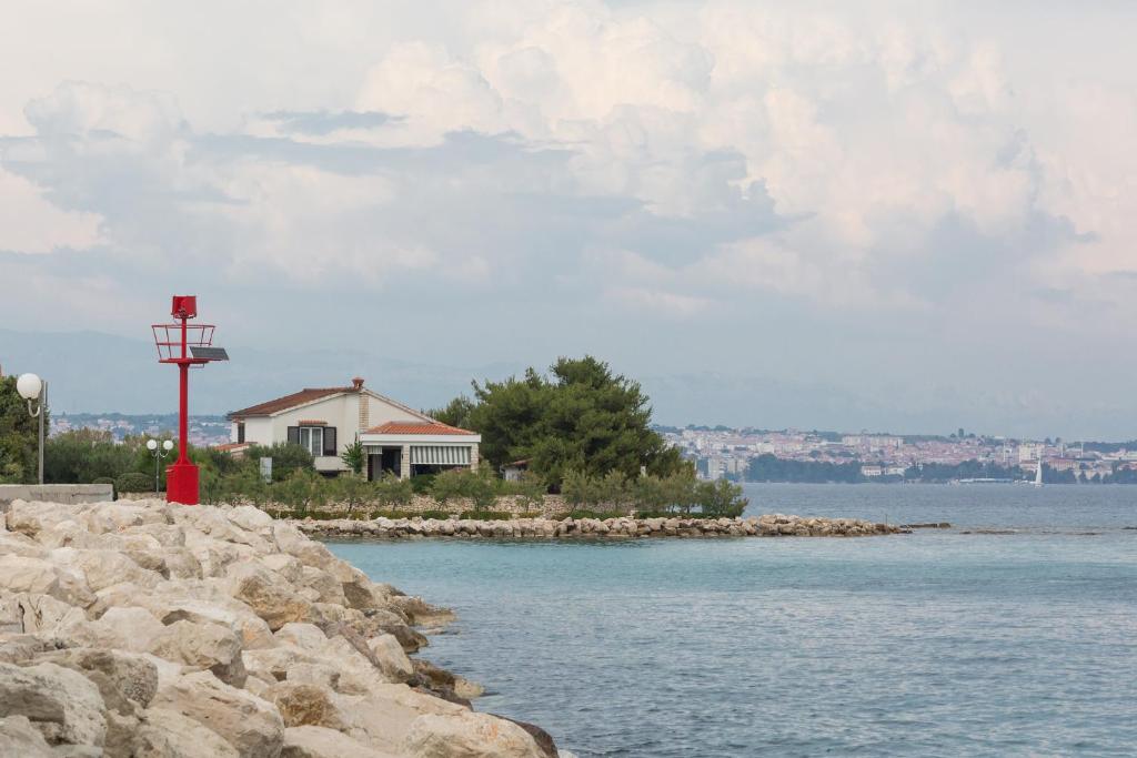 a house on the shore of a body of water at Beach apartment M & B in Poljana