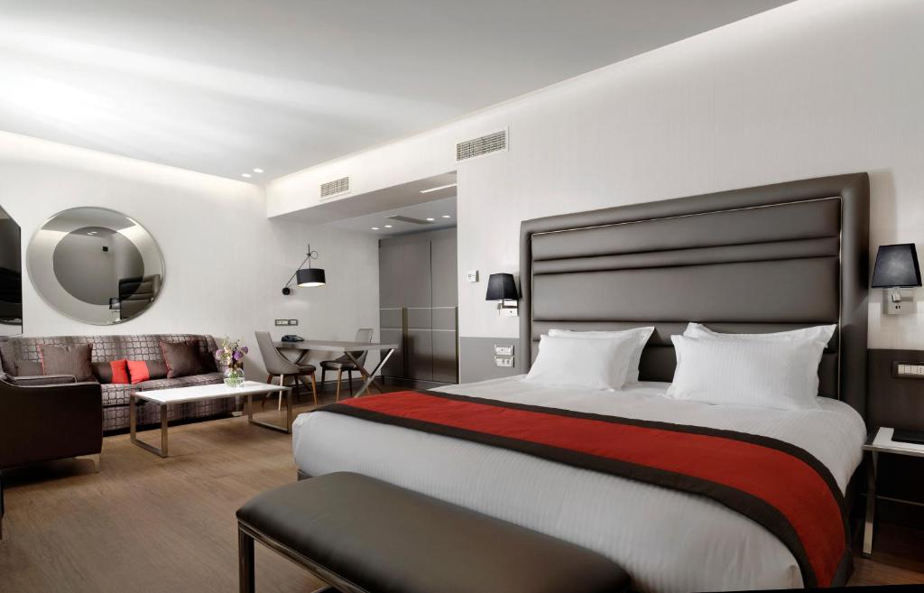 a bedroom with a large bed and a living room at Holiday Suites in Athens