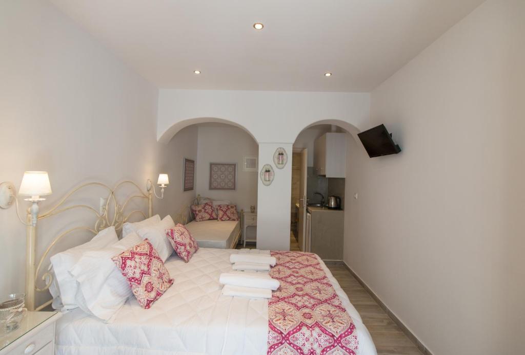 a bedroom with a large white bed with pink pillows at Relax Studios in Naxos Chora