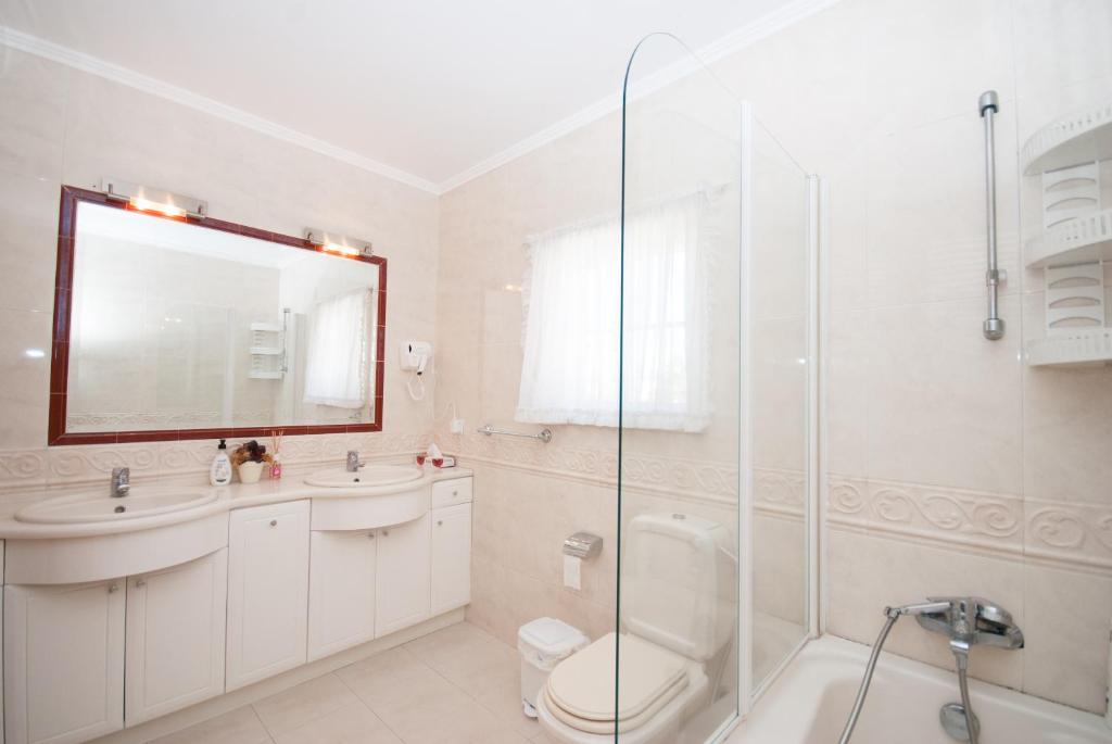 a bathroom with a sink toilet and a shower at Grace Villa in Aldeia de Juso