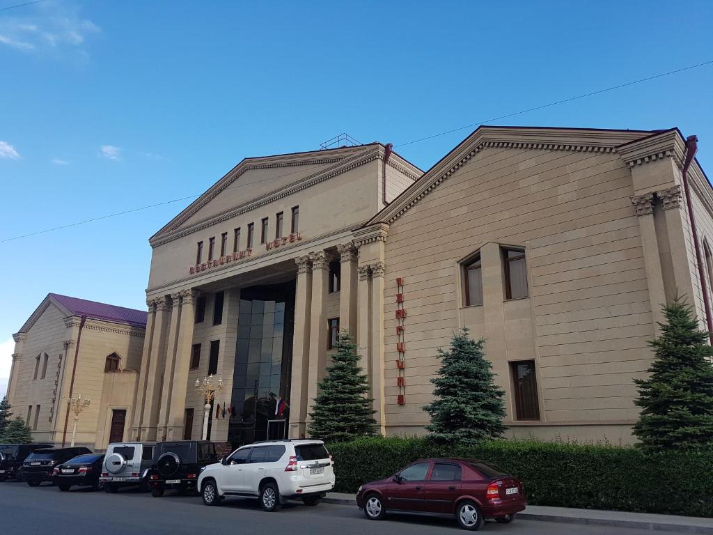 un bâtiment avec des voitures garées devant lui dans l'établissement Armenian Royal Palace, à Erevan