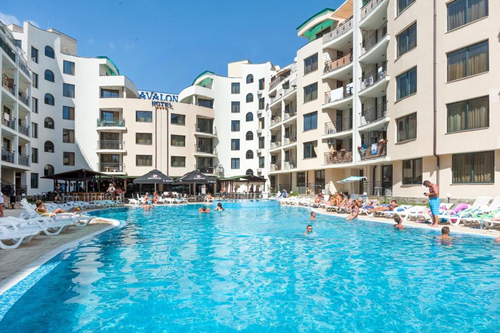 a swimming pool in a resort with people in it at Avalon Apartament in Sunny Beach