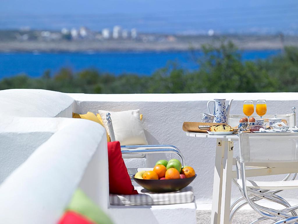 a table with a bowl of fruit and two glasses of orange juice at Villa Mare in Tersanas