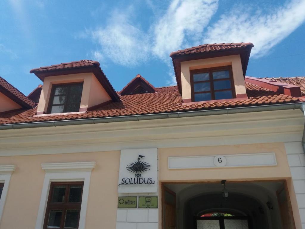 un bâtiment avec deux fenêtres au-dessus dans l'établissement Soludus-Spišský ľudový dom, à Smižany