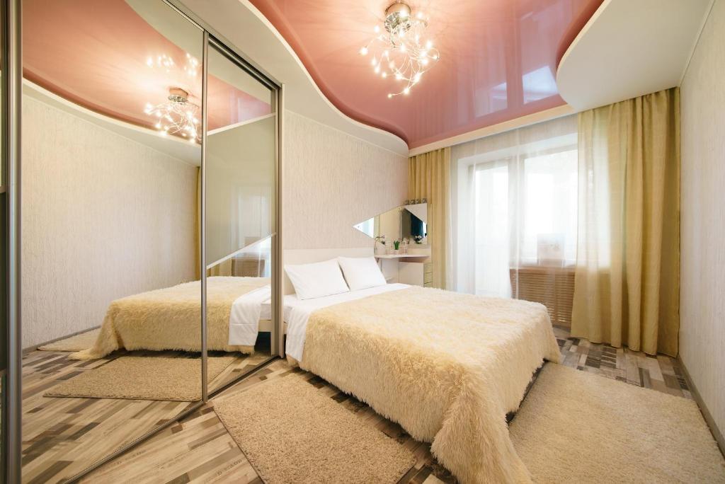 a bedroom with two beds and a mirror at PaulMarie Apartments on Voinov Internatsionalistov in Vitebsk