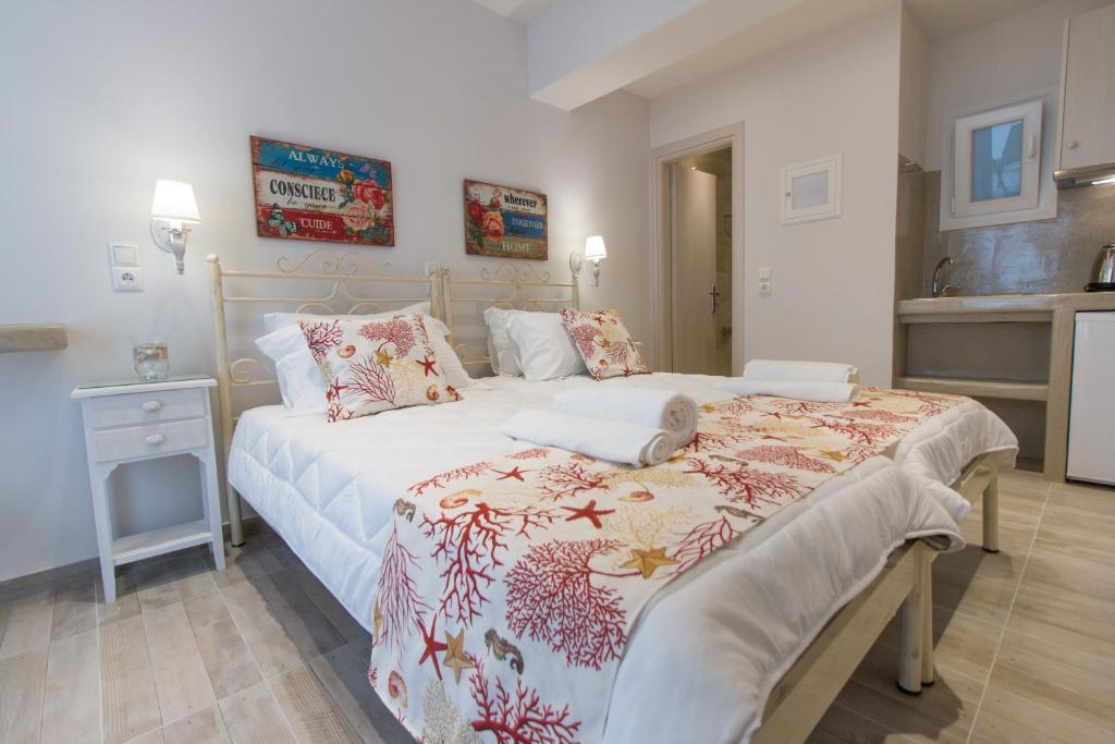 a bedroom with a large bed and a kitchen at Relax Studios in Naxos Chora