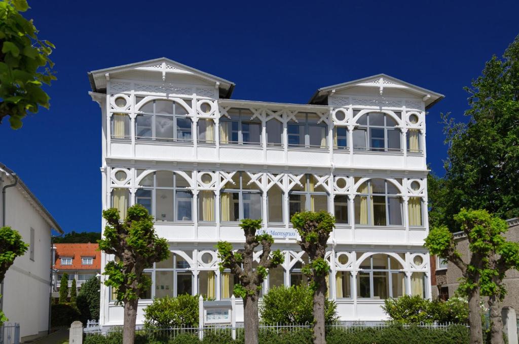 a white building with trees in front of it at Villa Meeresgruss in Ostseebad Sellin