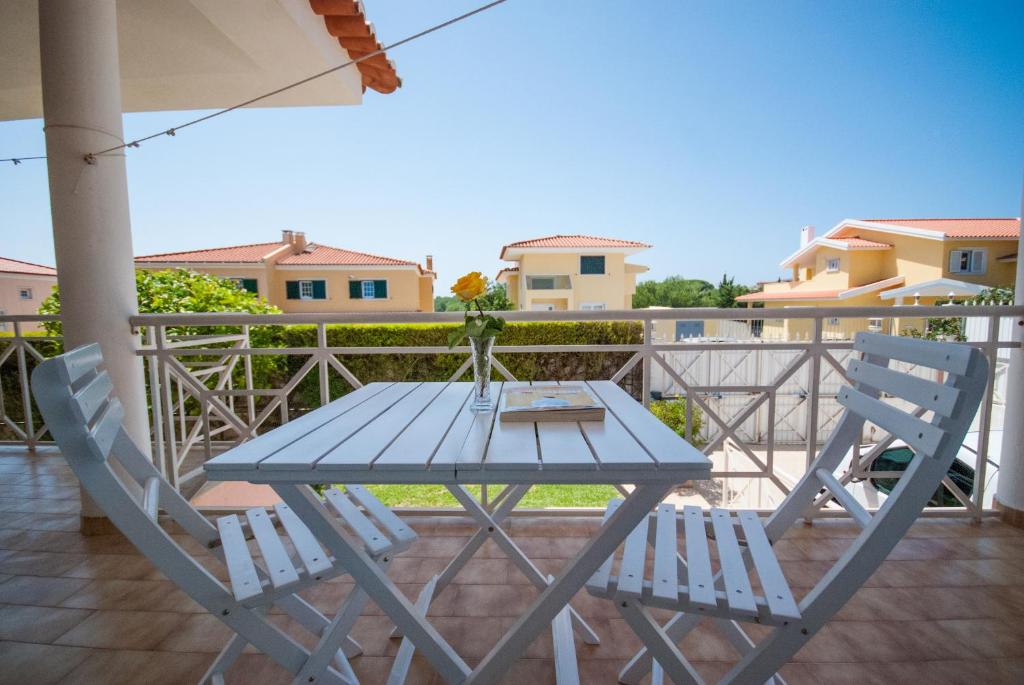 a blue table and two chairs on a balcony at Grace Villa in Aldeia de Juso