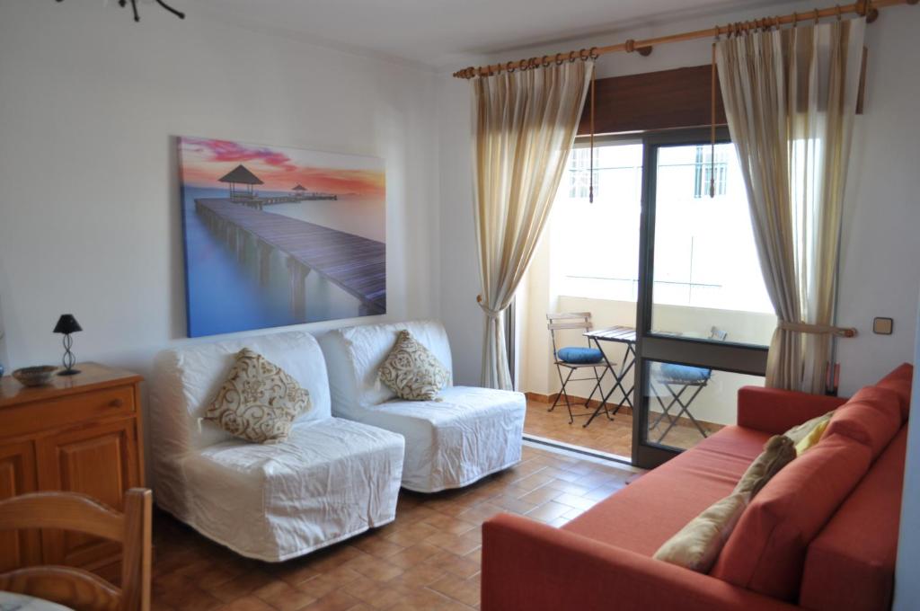 a living room with a couch and chairs and a table at Apartamento do Rio in Armação de Pêra