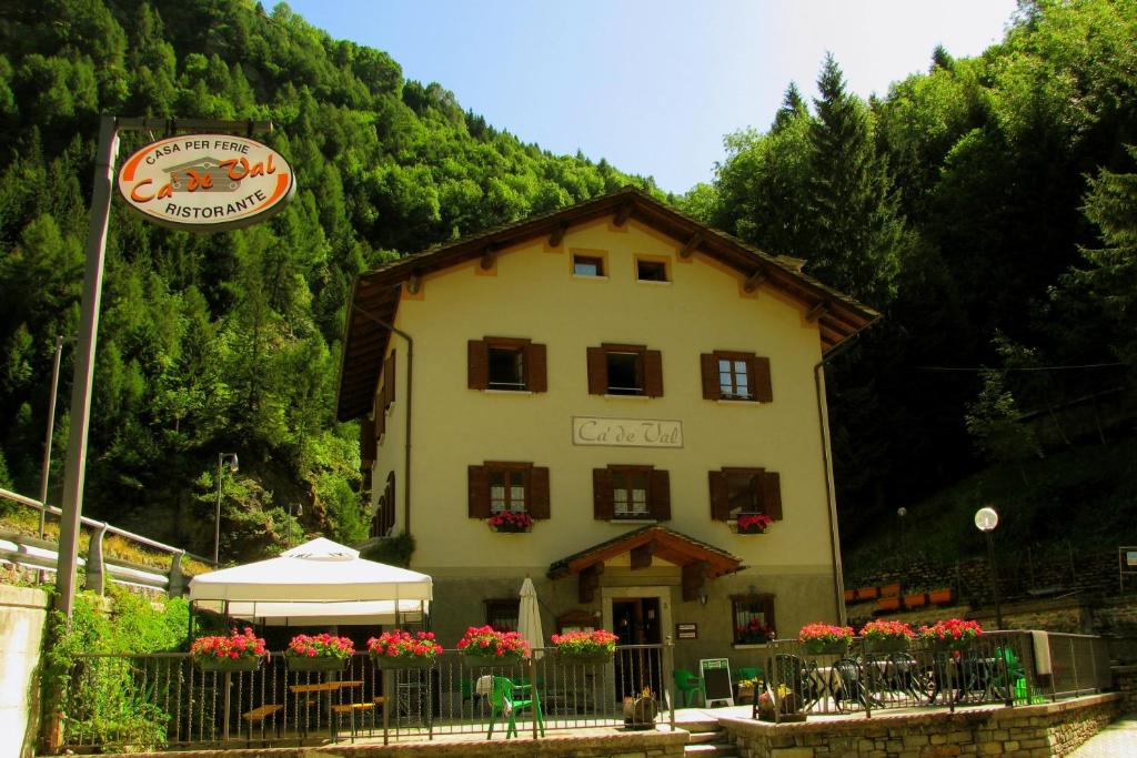 un edificio con un cartello di fronte di Casa Vacanze Ca' De Val a Campodolcino