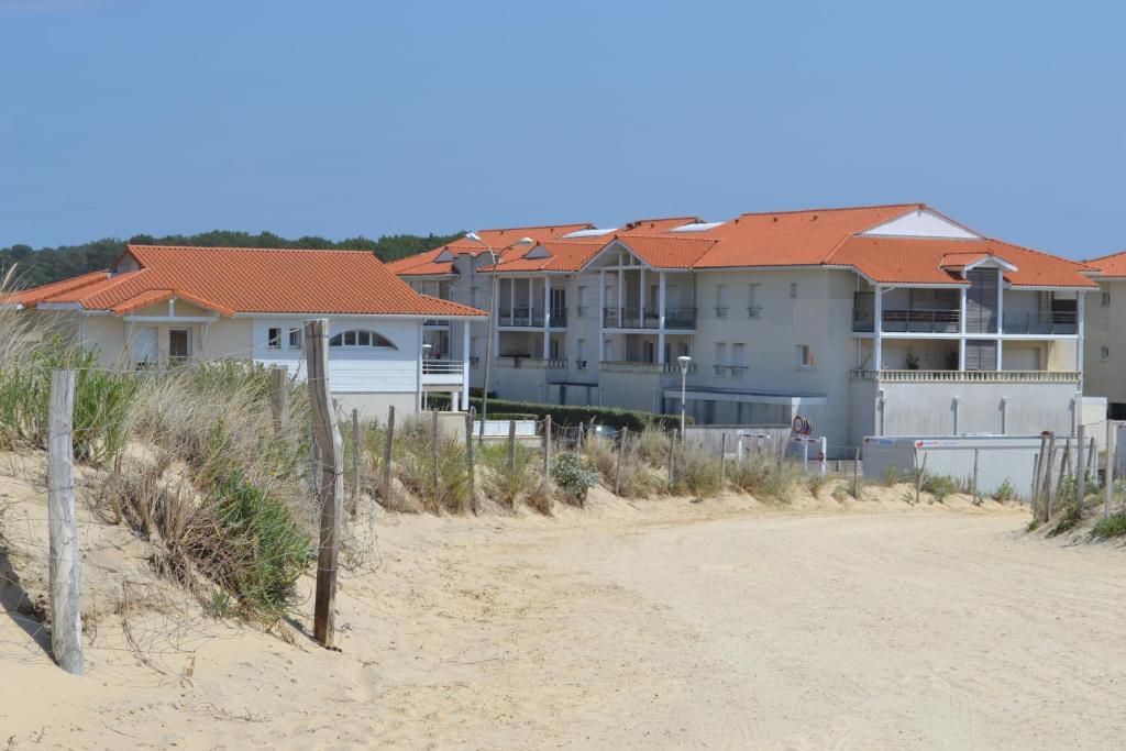 Une rangée de maisons sur la plage avec un chemin de terre dans l'établissement Residence Oceanis, à Biscarrosse-Plage