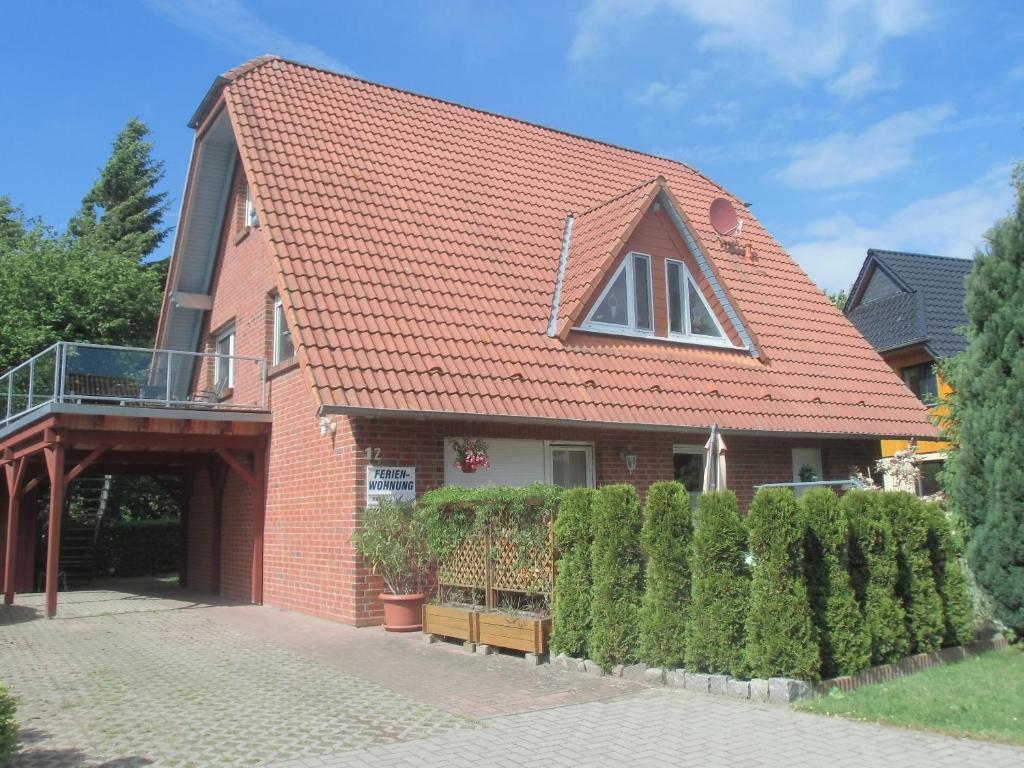 uma casa de tijolos com um telhado vermelho e uma cerca em Tor zum Darss em Pruchten