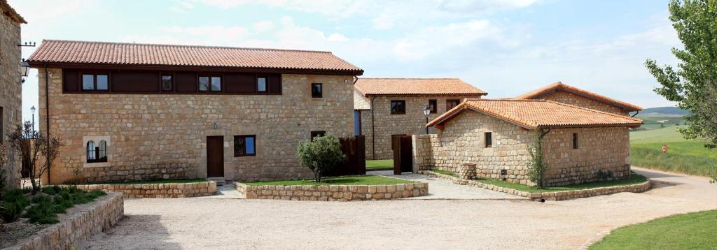 een groot bakstenen huis met twee gebouwen bij Complejo Rural las de Villadiego in Villalibado