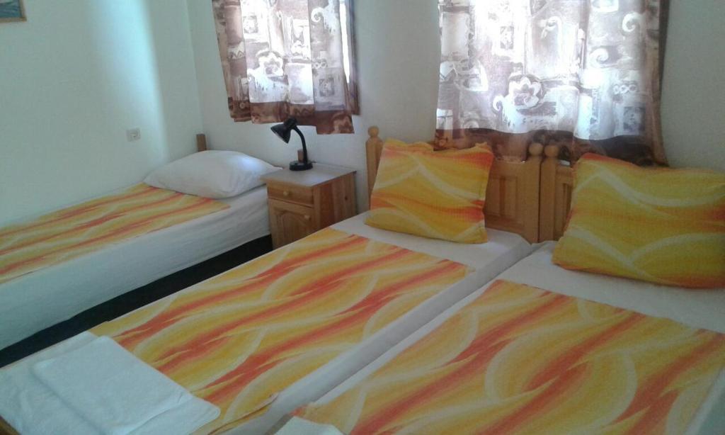 a bedroom with two beds with colorful blankets and pillows at Agalina Sea House in Sozopol