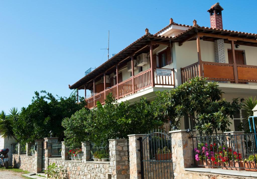 une grande maison avec une clôture devant elle dans l'établissement Pansion Matoula, à Skiathos Chora