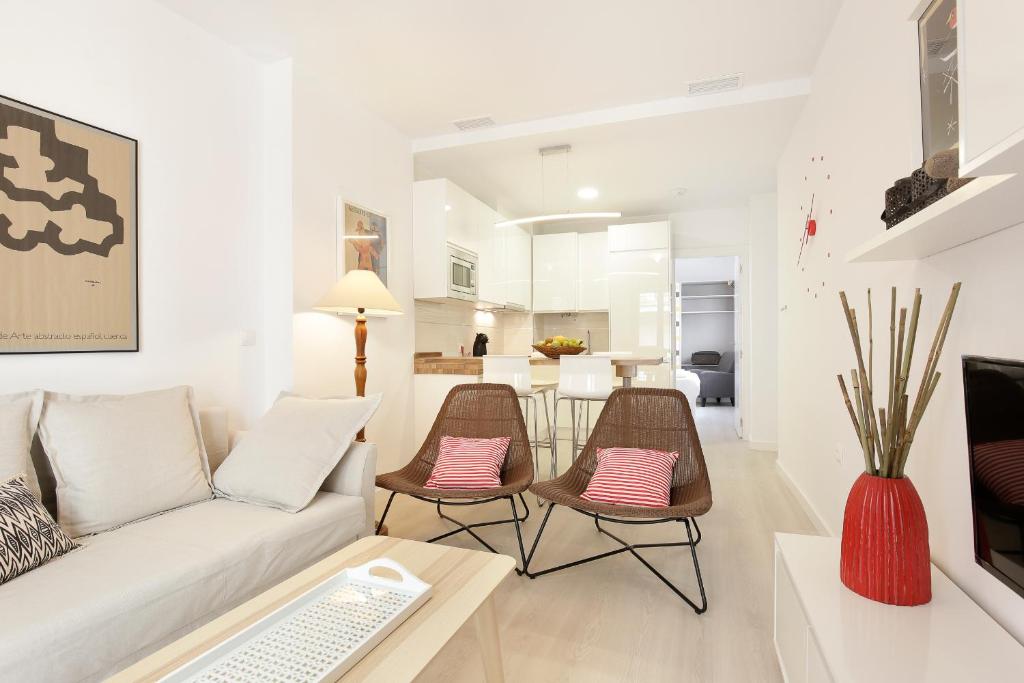 sala de estar con sofá, sillas y mesa en HI ROOM - Smart Apartments - AC, en Granada