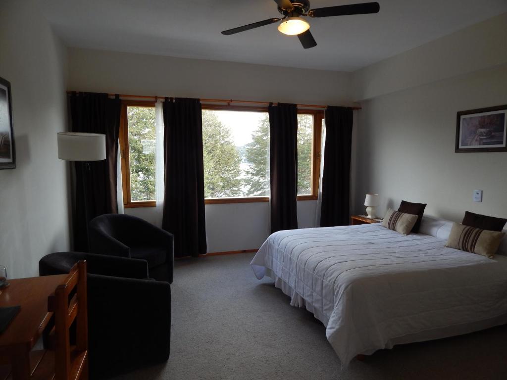 a bedroom with a bed and a ceiling fan at Peninsula de los Coihues in Villa Pehuenia