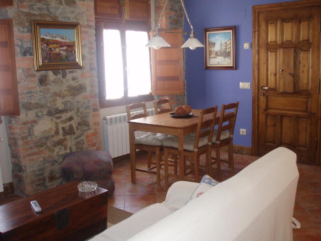 salon ze stołem i kanapą w obiekcie Apartamentos Casa María Juanín w mieście Collanzo