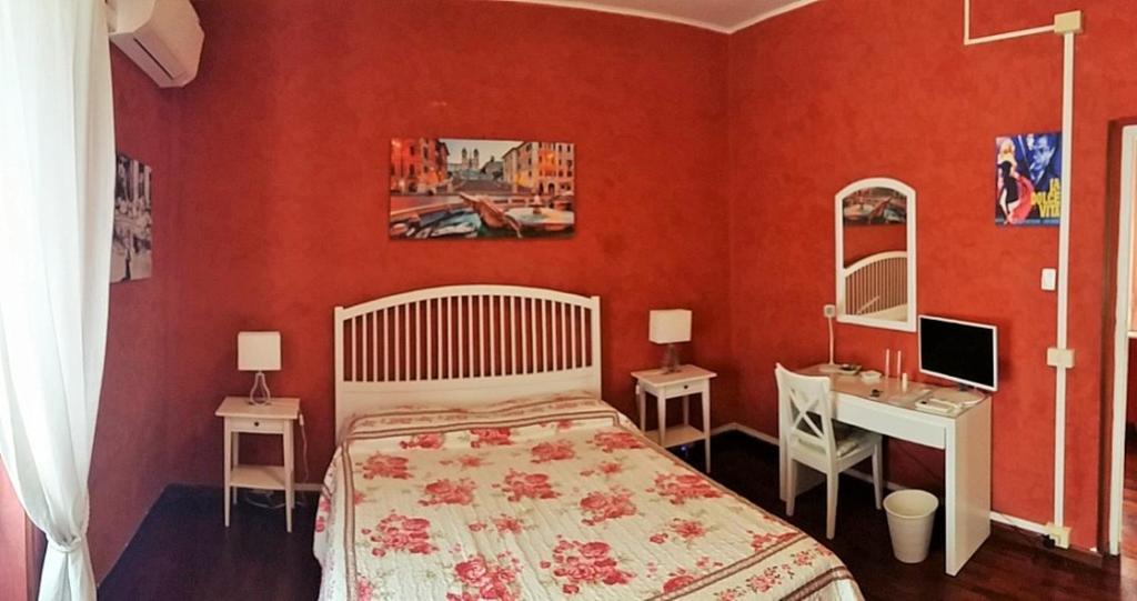 um quarto com paredes vermelhas, uma cama e uma secretária em CiaoRoma! em Roma