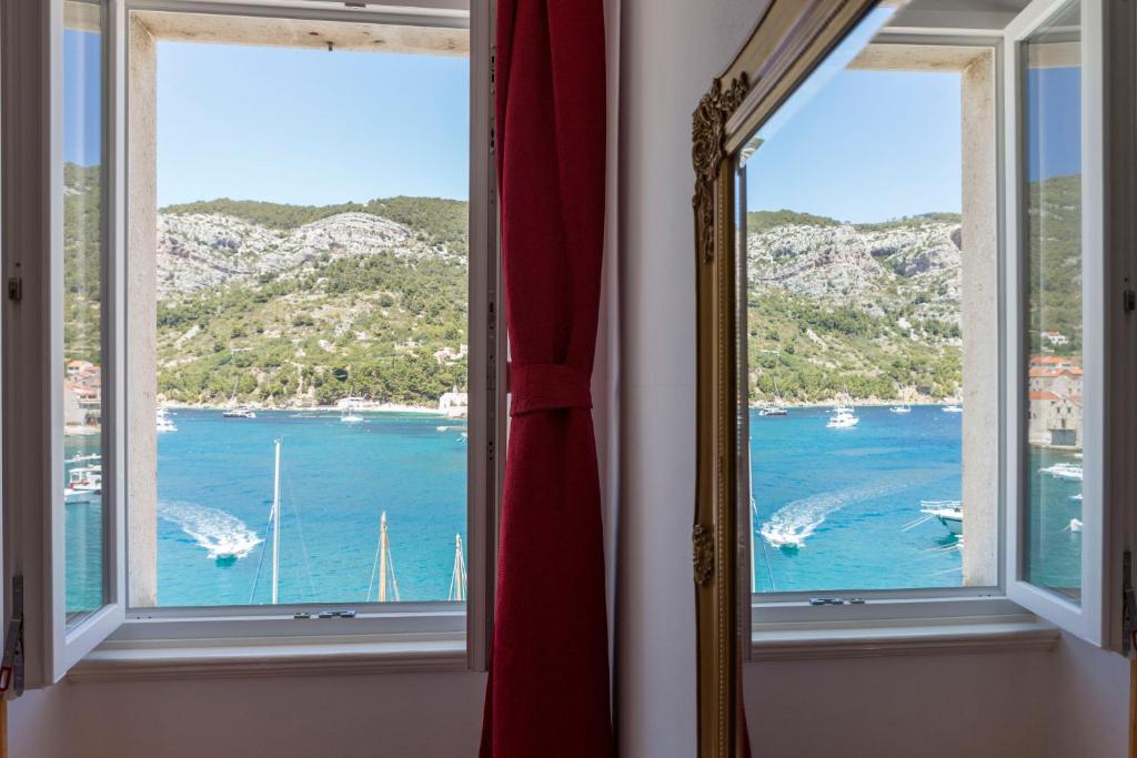 una ventana con vistas al agua y a los barcos en Apartment Riva 5 en Komiža