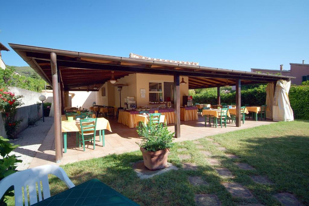 d'une terrasse avec des tables et des chaises dans la cour. dans l'établissement Hotel Anselmi, à Marciana Marina