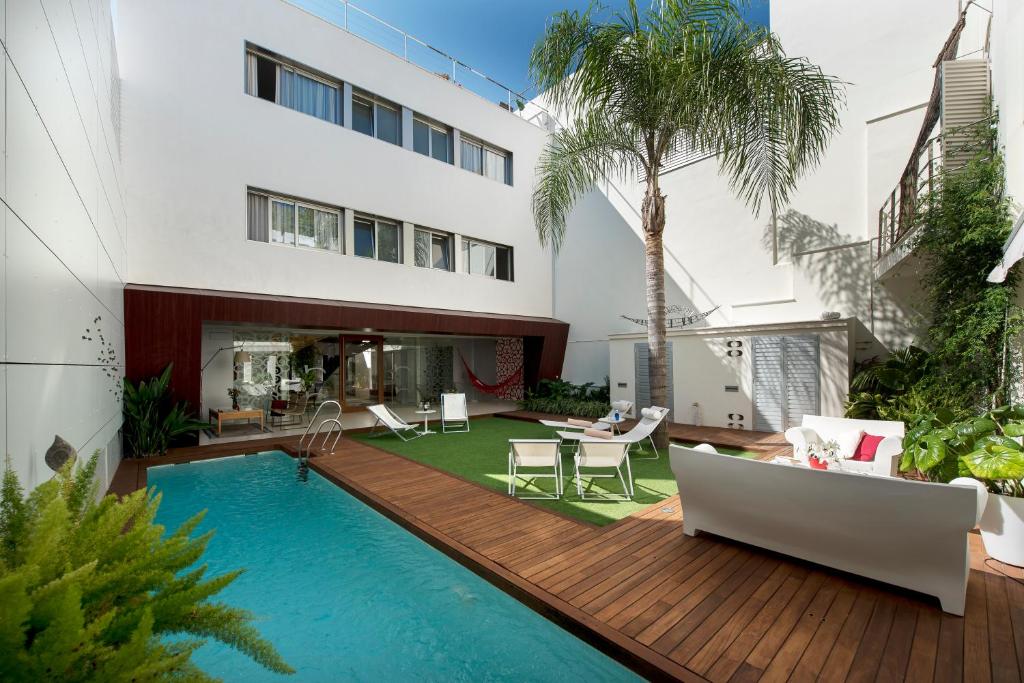 a house with a wooden deck and a swimming pool at La Alcoba del Agua hotel boutique in Sanlúcar de Barrameda