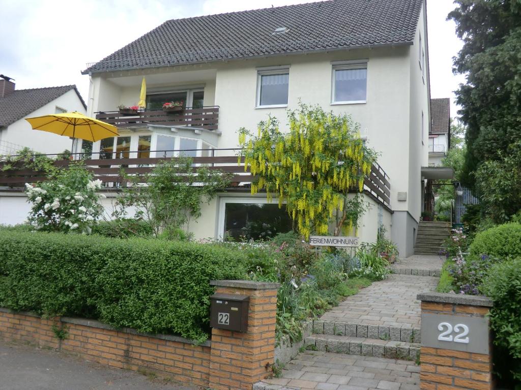 Uma casa branca com um guarda-chuva à frente. em Ferienwohnung Kehmeier em Polle