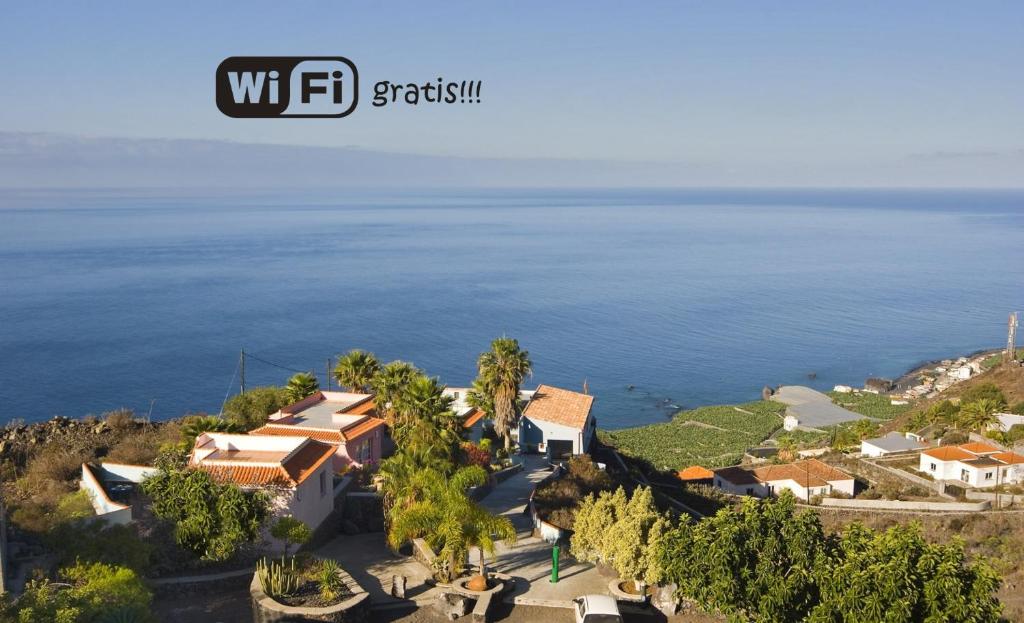 una imagen de una casa en una colina con vistas al océano en Bungalows & Apartamentos Morani, en Puerto Naos