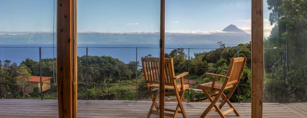 two chairs on a balcony with a view of a mountain at Intact Farm Resort in Velas