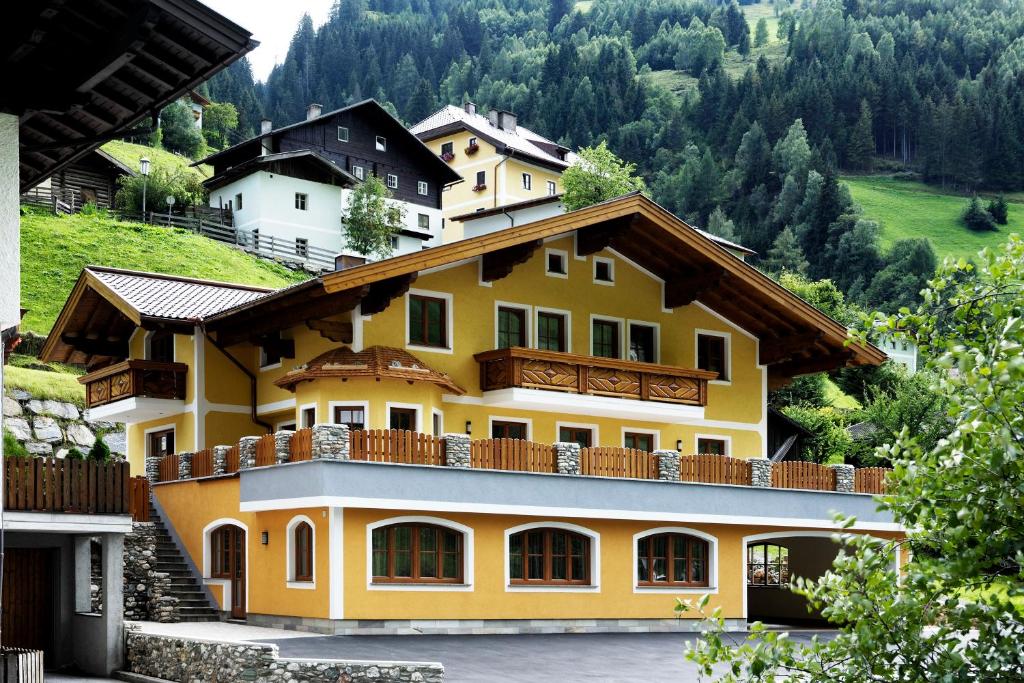 HüttschlagにあるHaus Alpenquellの木立の黄色い家