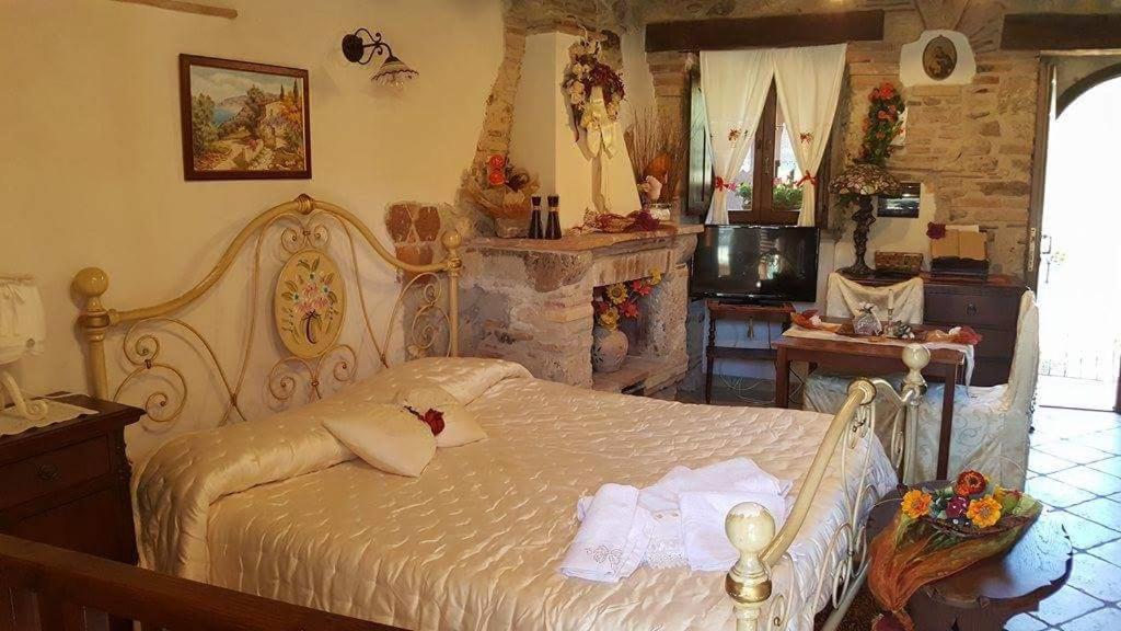 um quarto com uma cama grande e uma lareira em B&B La Casetta sul Lago em Colle di Tora