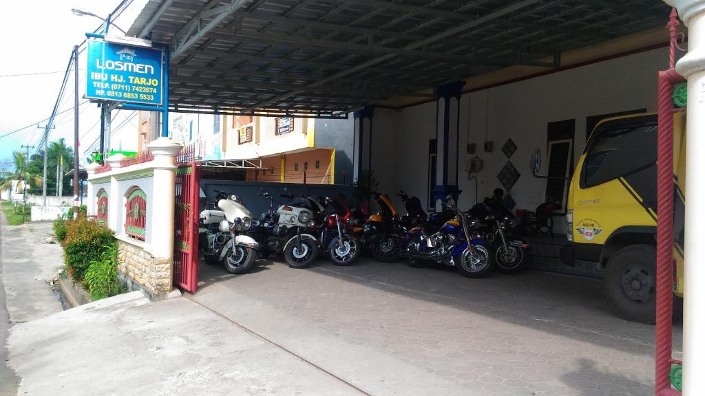 a group of motorcycles parked in a garage at Losmen Ibu Hj. Tarjo in Palembang