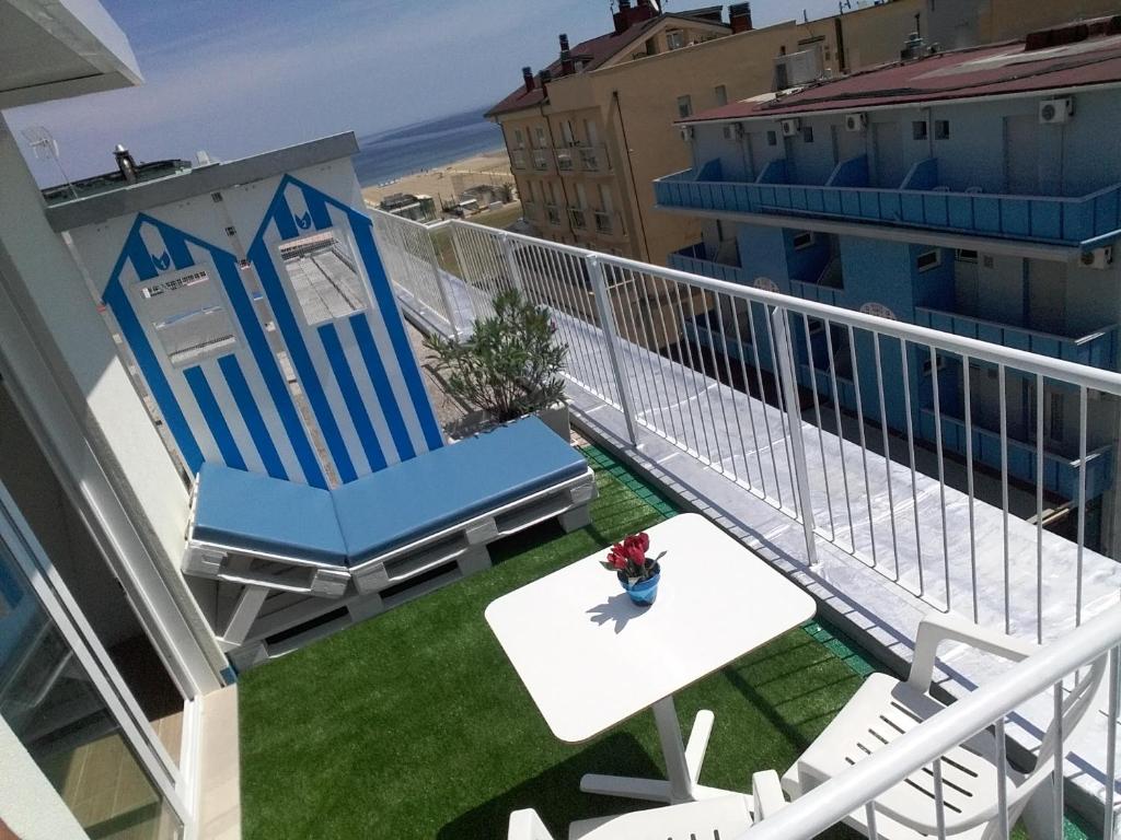 a balcony with a blue chair and a table at Hotel Haarlem in Rimini