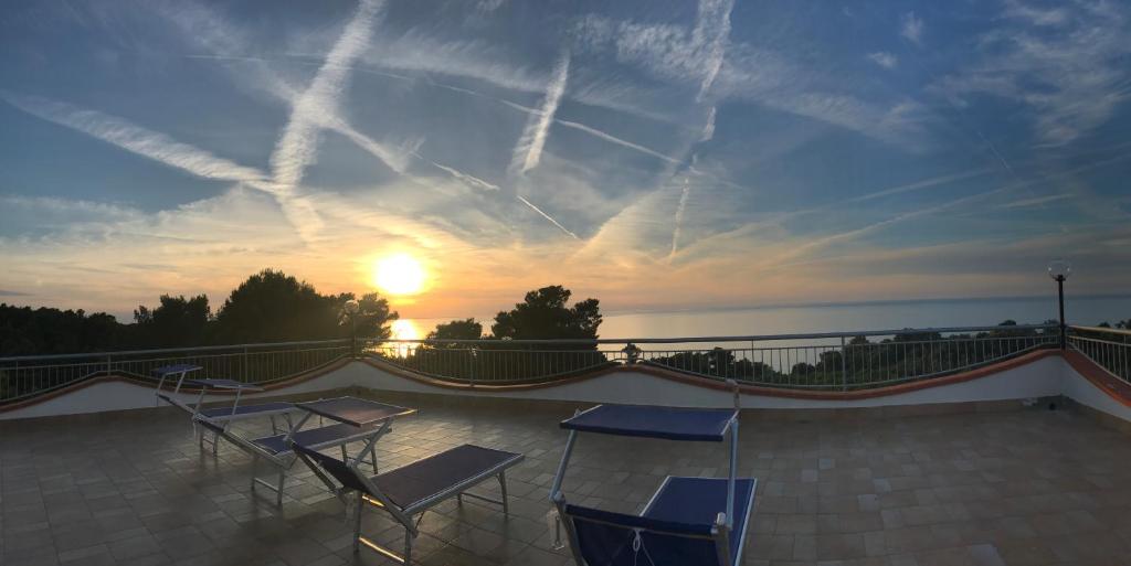 un patio con sedie e il tramonto sullo sfondo di Villa Anna Residence Rodi a Rodi Garganico