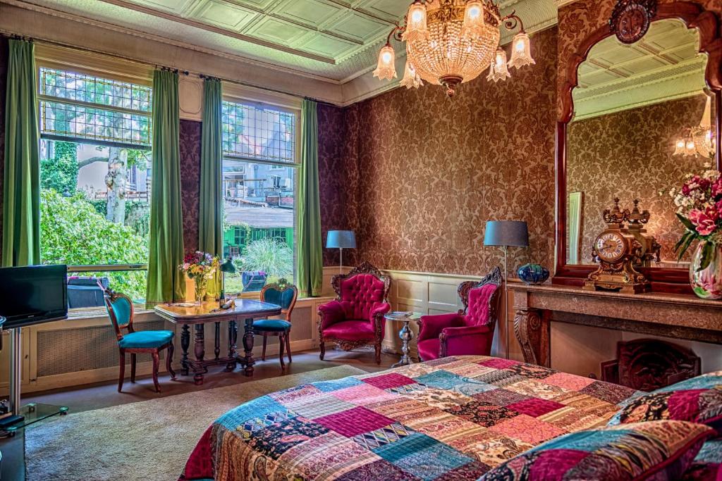 een slaapkamer met een bed en een tafel en stoelen bij B&B Het Hart van Haarlem in Haarlem